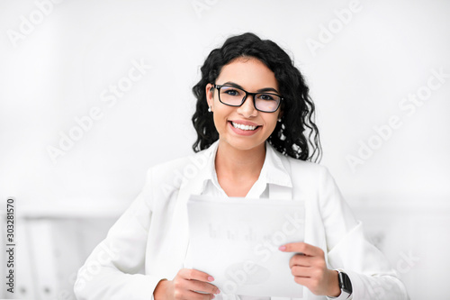 Attractive recruiter holding documents, looking at camera photo