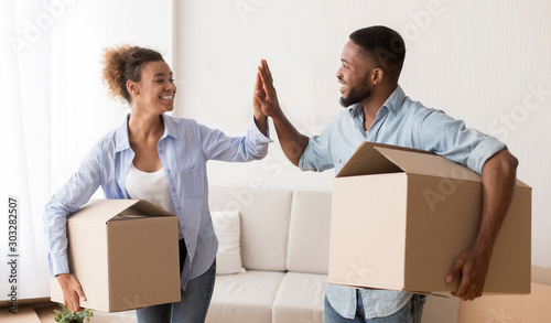 Afro Couple Giving High-Five Carrying Moving Boxes Entering New House