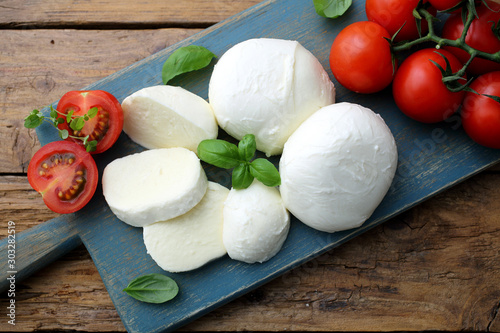 mozzarella prodotto tipico Italiano derivato dal latte con pomodori e basilico photo