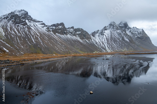 Landscape of Vesturhorn mountains with reflections in Southeast Iceland during winter time.