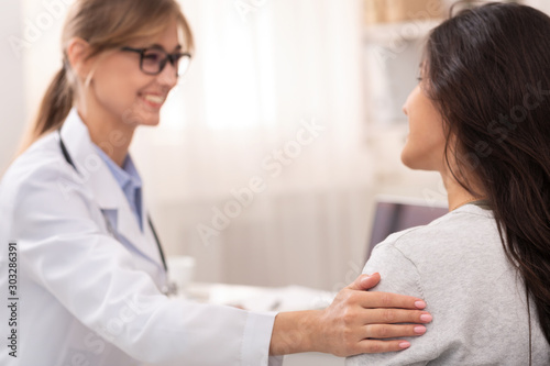 Doctor Lady Comforting Patient During Checkup In Clinic