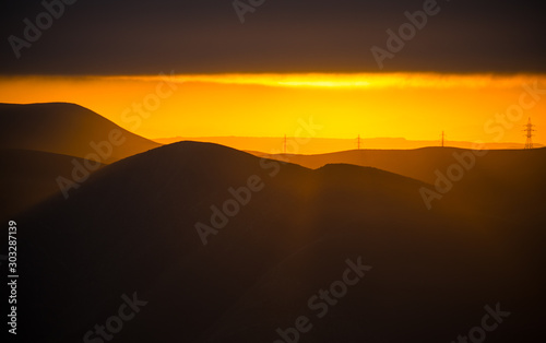 Cloudy weather. Zoom shot. Orange sunset view at mountains in Azerbaijan