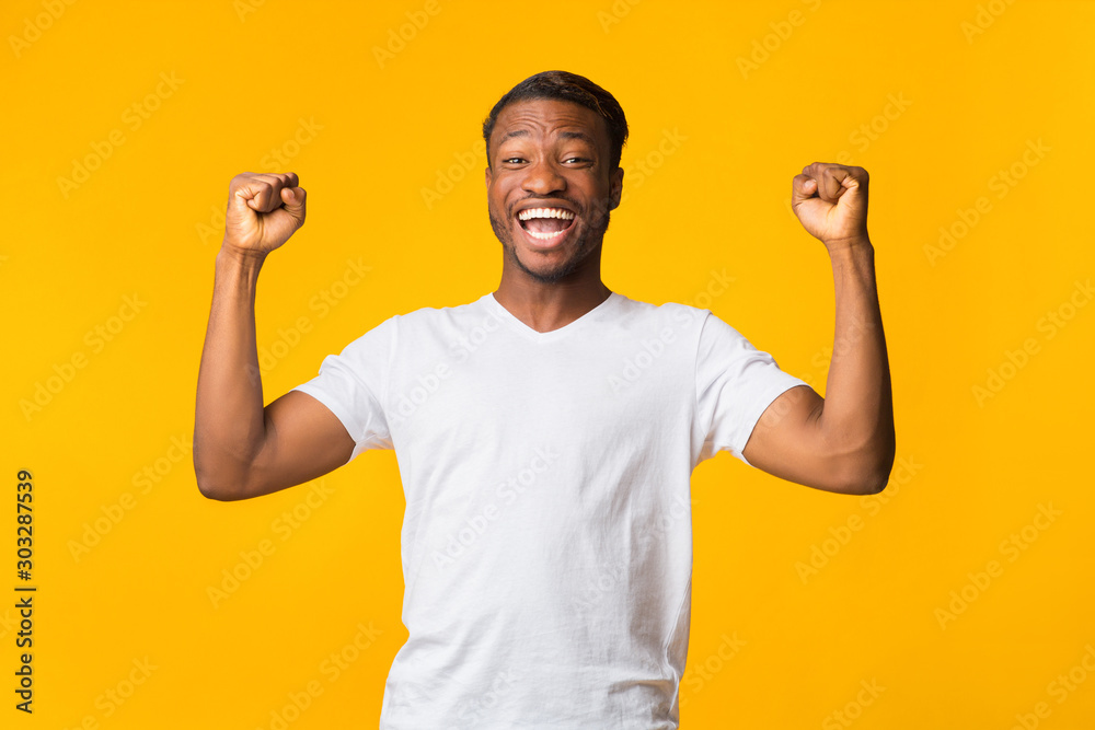 Joyful Afro Man Shouting Shaking Fists Celebrating Success, Studio Shot Joyful Afro Man Shouting Shaking Fists Celebrating Success, Studio Shot