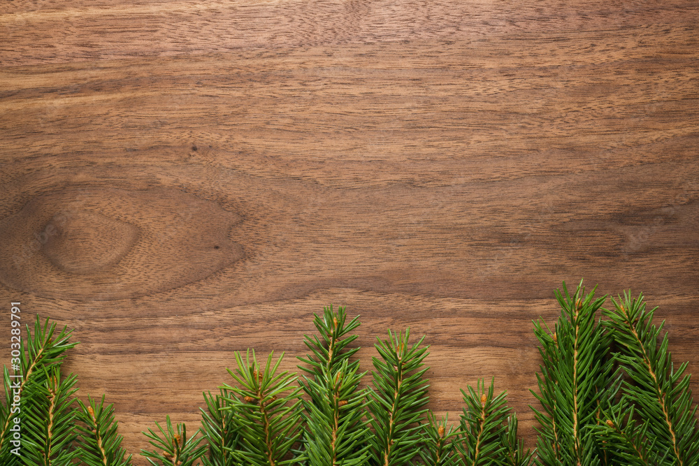 Top view of green spruce twigs on walnut wood surface Top view of green spruce twigs on walnut wood surface