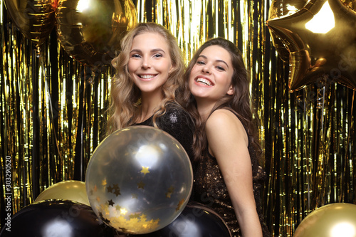 Beautiful girls celebrating New Year. Gorgeous smiling young women enjoying party celebration, having fun together.