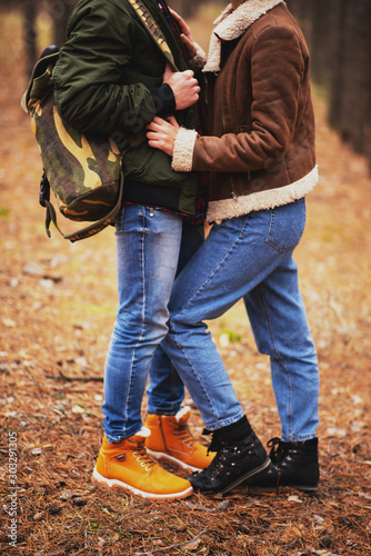 romantic couple, a guy and a girl walk in the autumn cold forest and drink tea