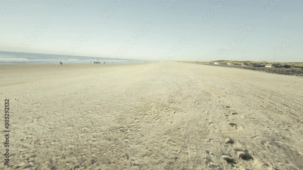 Fast aerial shot of a beach in Domburg with people surfing. Fast aerial shot of a beach in Domburg with people surfing.