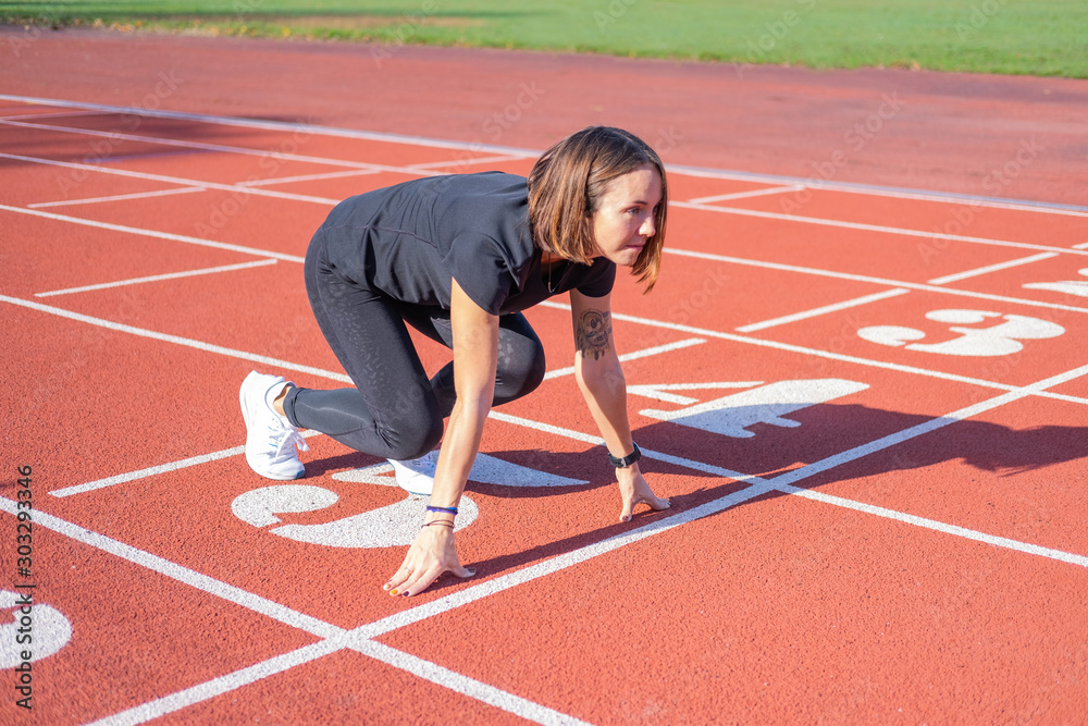 Young female runner training in summer day outdoors on the studium 