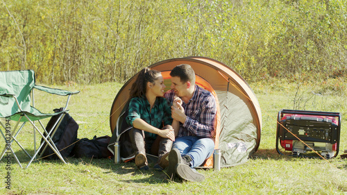 Adorable young couple having a sweet moment in camping tent