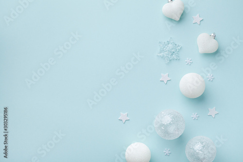 White Christmas decorations on mint pastel background. Christmas or New year holiday card top view. Minimalistic flat lay style.