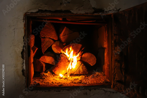 Hot flame and firewood in old stove in the village