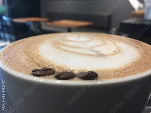 cup of coffee with cream on wooden background