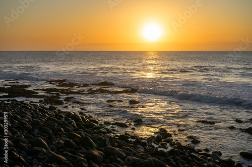 Ocean sun sets against lava shoreline in Canary Island  Spain
