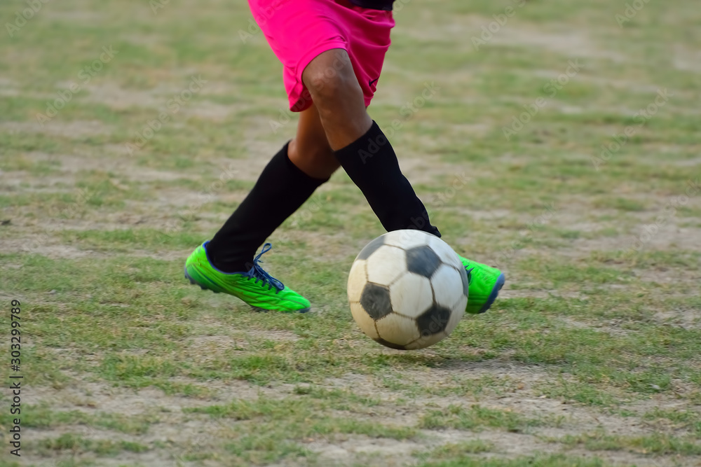 Soccer player is kicking ball during football practice in field