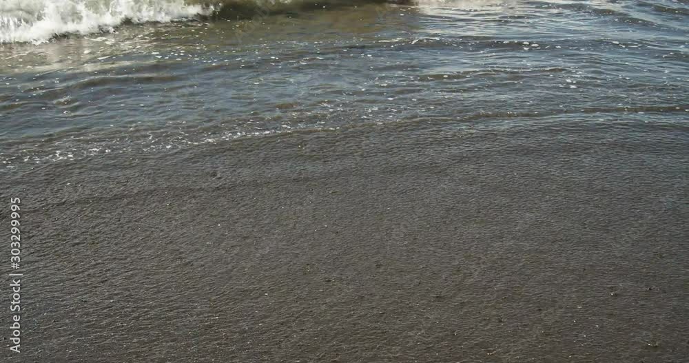 Sea waves with white foam on black golden sand beach. Morning and evening tides. Sea waves with white foam on black golden sand beach. Morning and evening tides.