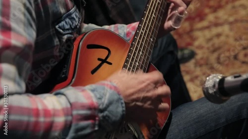 man playing acoustic guitar with a bottleneck