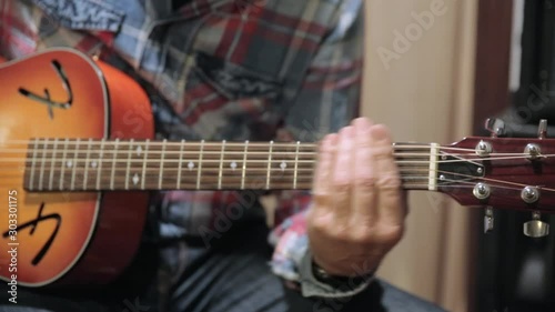 slide guitar - man playing acoustic guitar with a bottleneck