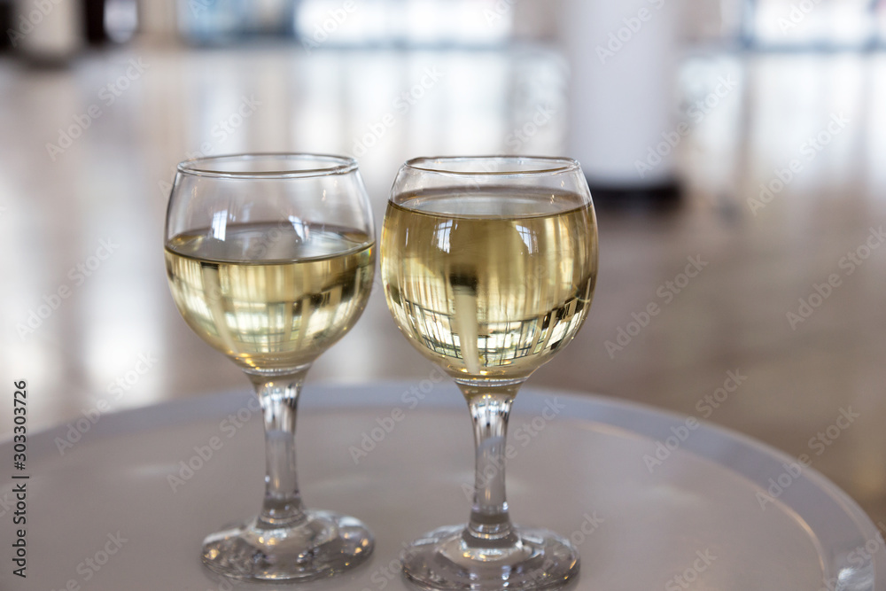 Two glasses of white wine in a hotel lobby, selective focus Two glasses of white wine in a hotel lobby, selective focus