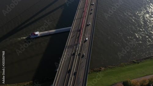 Cargo boat on the river Rhine passing under the Fleher Bridge in Duesseldorf, Germany // Camera rotating slowly photo