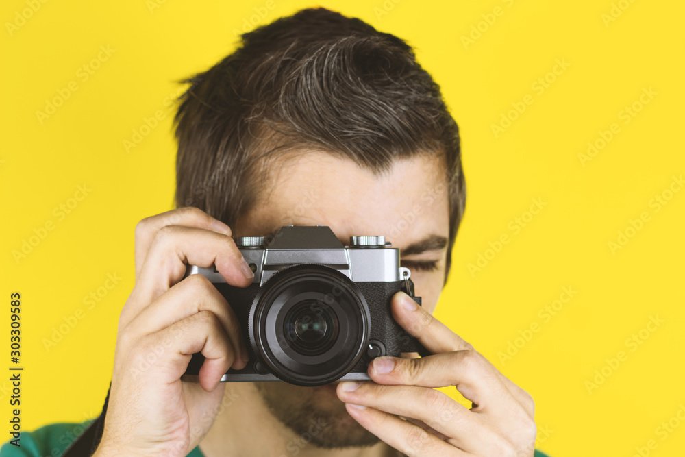 yong handsome man holding photo cavera isolated on yellow background yong handsome man holding photo cavera isolated on yellow background