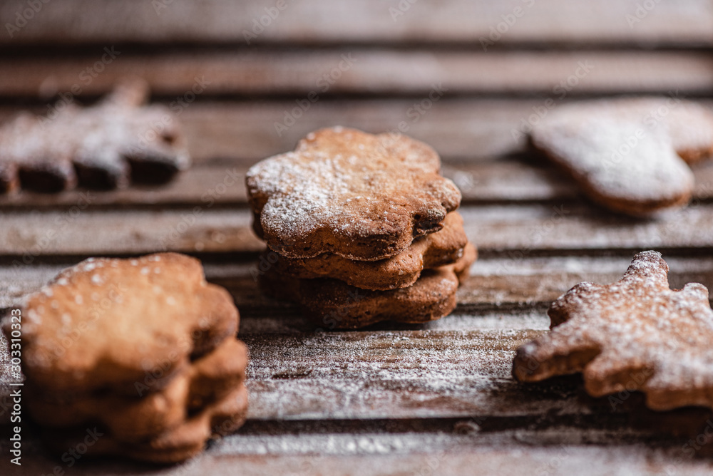 Christmas pastries. Homemade freshly baked cookies sprinkled with icing sugar on a wooden table. Close-up. Christmas pastries. Homemade freshly baked cookies sprinkled with icing sugar on a wooden table. Close-up.