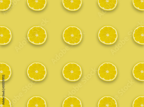 Pattern.Fresh lemon slices on a yellow background.Flat lay, top view - image background.