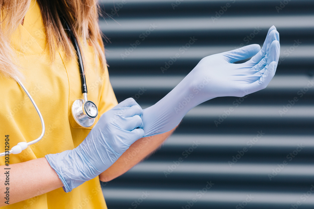 Manos de enfermera poniéndose guantes de látex azules. Stock Photo | Adobe  Stock