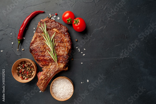 Grilled beef steak with spices on a stone background with copy space