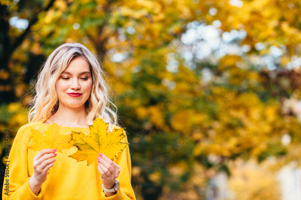 Autumn woman. Autumn Clothing and color trends. Smiling funny girl playing with leaves. Autumn woman. Beautiful autumn woman on fall nature background Autumn woman. Autumn Clothing and color trends. Smiling funny girl playing with leaves. Autumn woman. Beautiful autumn woman on fall nature background