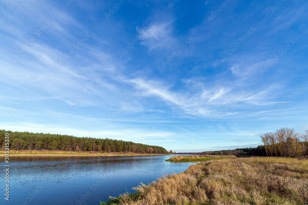 Obraz premium The blue sky with the clouds above the clear blue river.