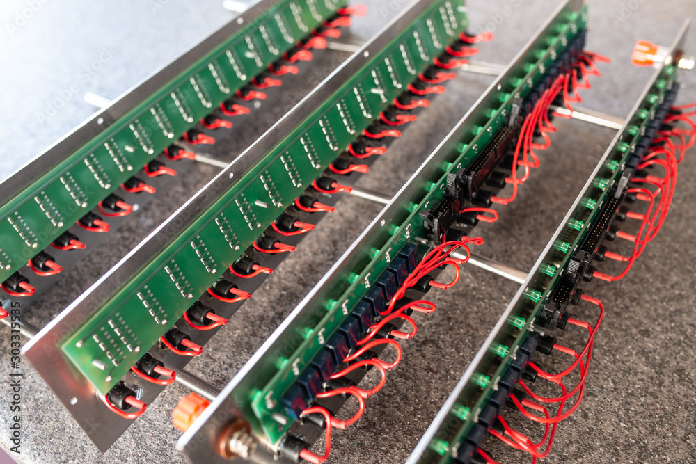 Obraz premium Close-up of a metal panel with microchips connected to each other with red wires in the manufacture of electronic equipment. The concept of complex technical equipment at the factory