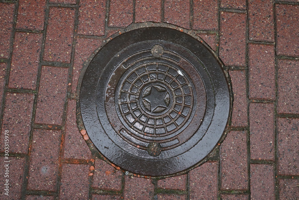 Manhole cover  on the cobblestone road