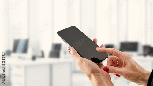 Smartfon, telefon w kobiecych dłoniach na biznesowym tle