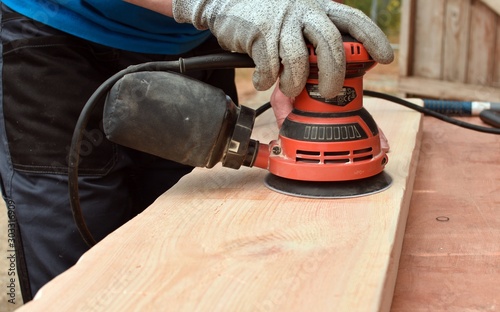 Sanding With Electric orbital sander. photo