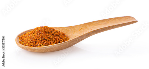 red chili pepper powder in spoon on white background