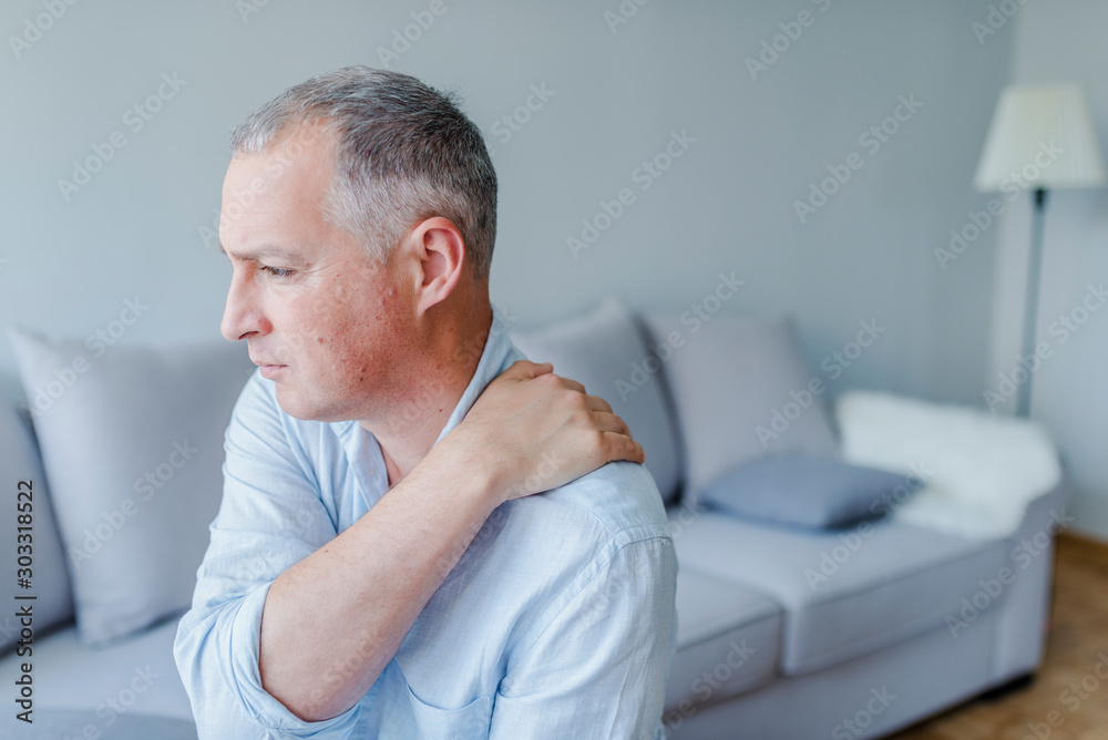 Young man suffering from pain in shoulder, closeup Young man suffering from pain in shoulder, closeup