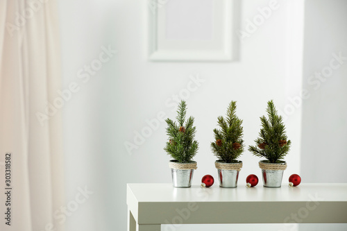 Wooden shelf with space for your decoration. White wall with frame picture background. Christmas composition.Winter time. Copy space. 