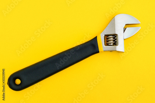 New adjustable spanner on a yellow background photo