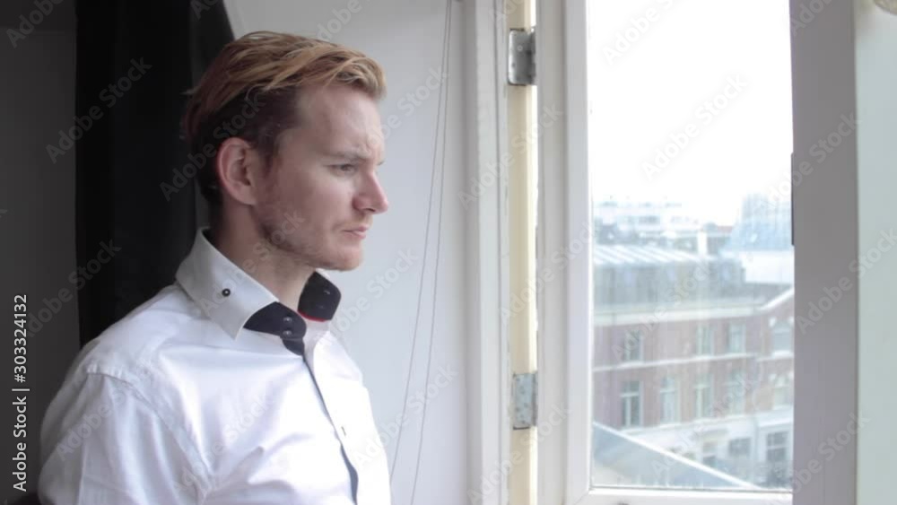 An elegant businessman drinks coffee at the window An elegant businessman drinks coffee at the window