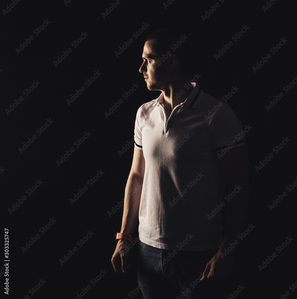 Adult man looking away at black background