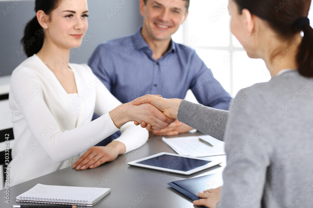 Group of business people shaking hands after discussing questions at meeting in modern office. Handshake close-up. Teamwork, partnership and agreement in business concept Group of business people shaking hands after discussing questions at meeting in modern office. Handshake close-up. Teamwork, partnership and agreement in business concept