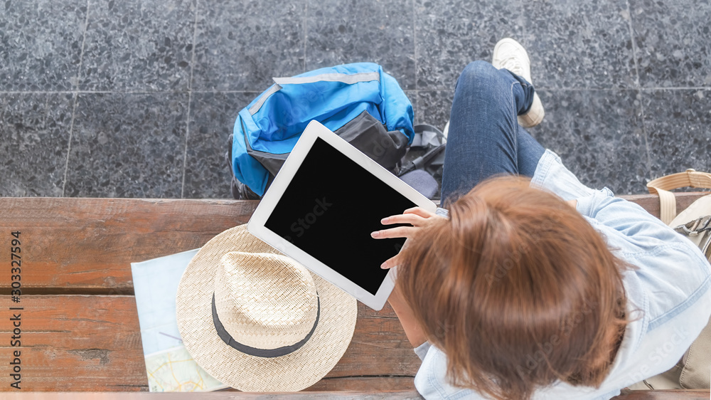 Obraz premium Woman traveler tourist using tablet at train station. Traditional train for transportation.
