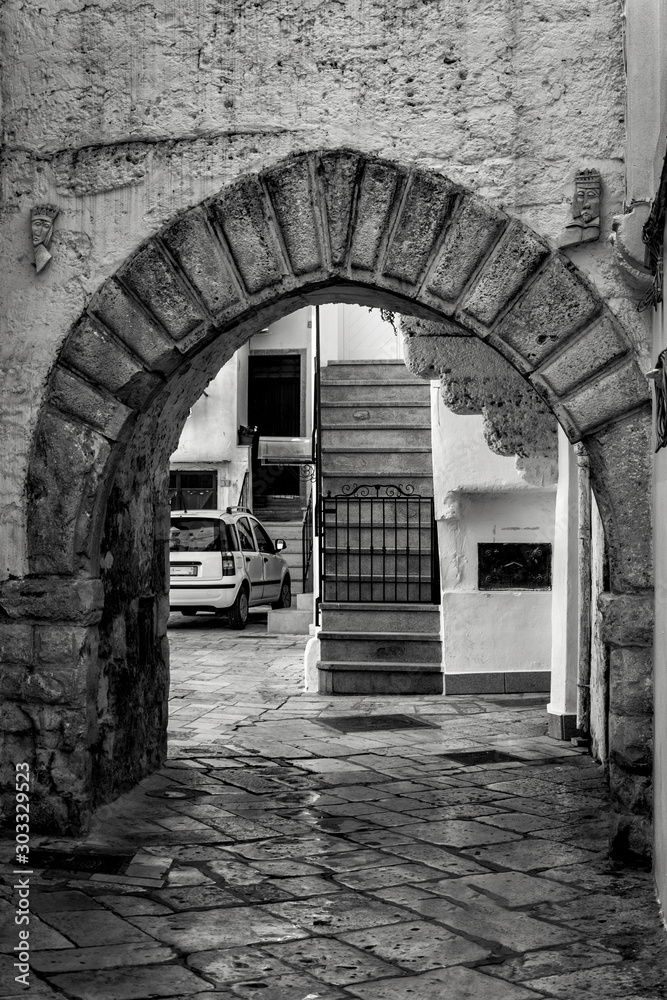 Antigua calle del casco antiguo con escaleras y arco Italia