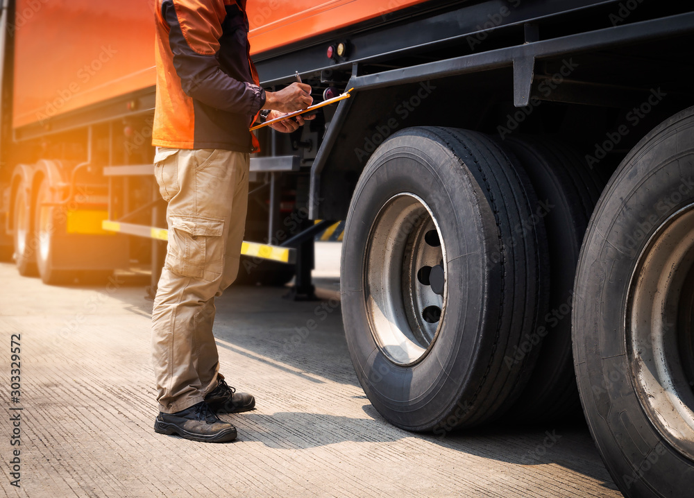 Truck Driver is Checking the Truck's Safety Maintenance Checklist. Fixing. Inspection Safety of Semi Truck Wheels Tires. Truck Driver is Checking the Truck's Safety Maintenance Checklist. Fixing. Inspection Safety of Semi Truck Wheels Tires.