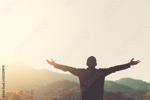 Copy space of silhouette man rising hands up on sunset sky and clouds abstract background.