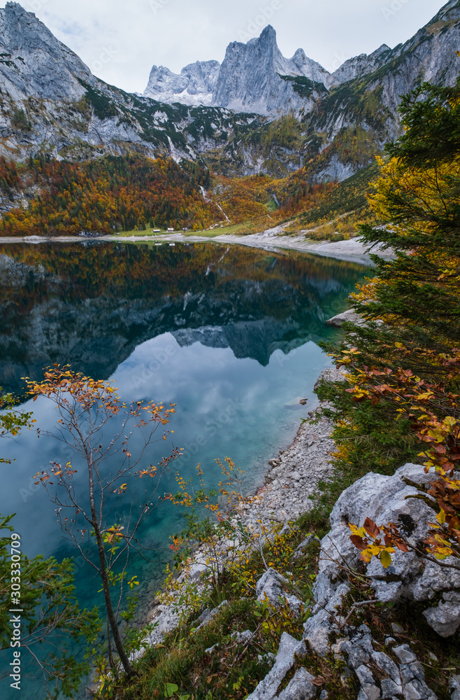 Picturesque Hinterer Gosausee lake, Upper Austria. Autumn Alps mountain lake with clear transparent water and reflections. Dachstein summit and glacier in far.