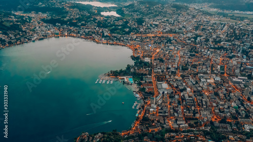 Fototapeta Naklejka Na Ścianę i Meble -  Aerial drone shot view of Lugano city by the lake with street light at dusk after sunset