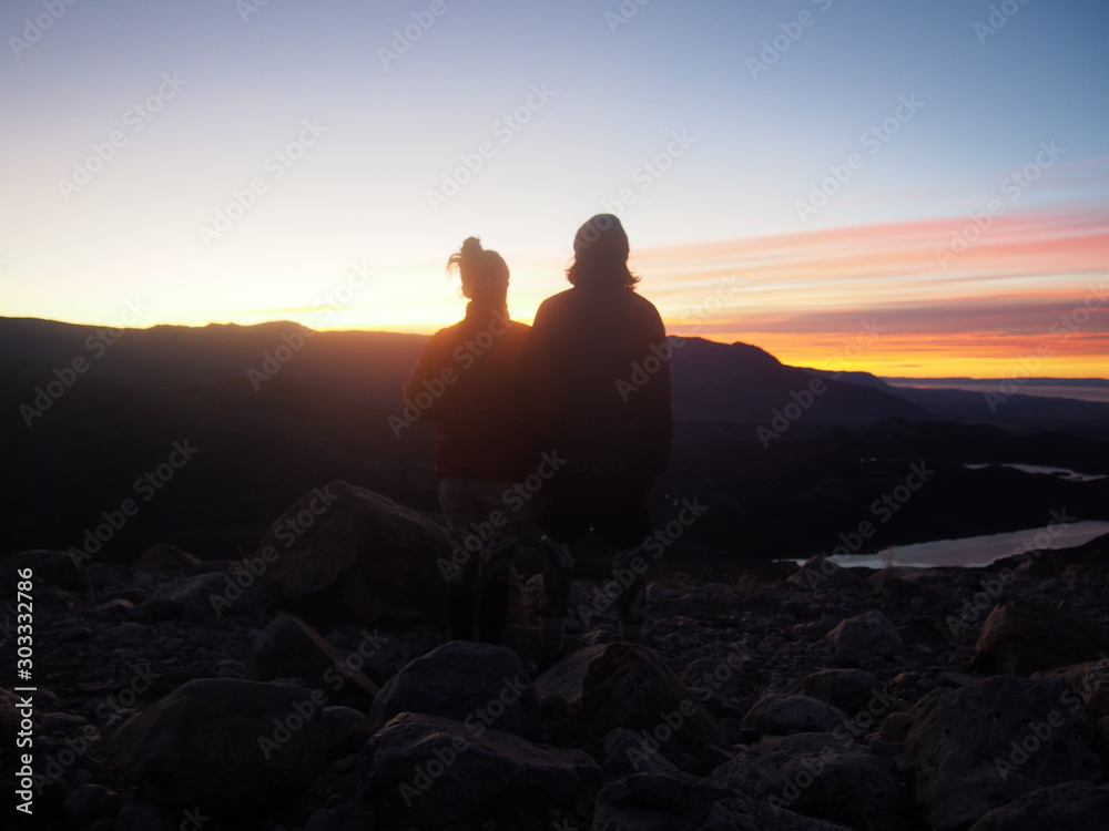 A couple of hikers watching the beautiful sunrise, Precious scenery created by nature, Mount Fitz Roy, Los Glaciares National Park near El Chalten, Patagonia, Argentina