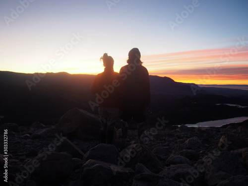 A couple of hikers watching the beautiful sunrise  Precious scenery created by nature  Mount Fitz Roy  Los Glaciares National Park near El Chalten  Patagonia  Argentina
