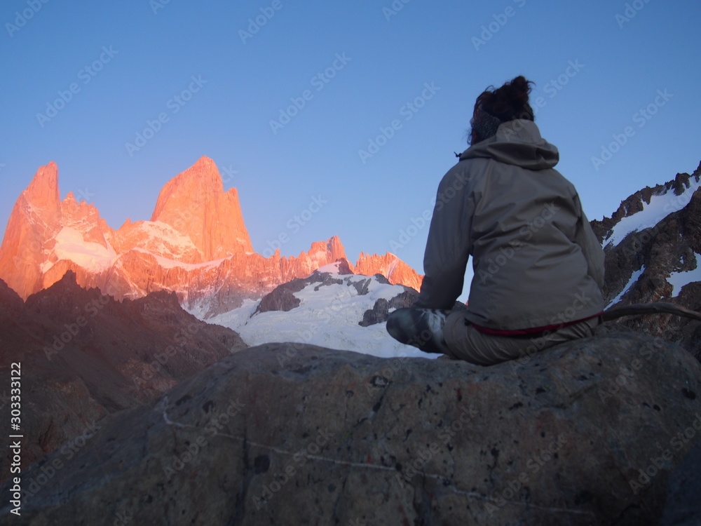 Φωτογραφία A woman hiker gazing at Mount Fitz Roy tinted red by the sunrise, Precious scene